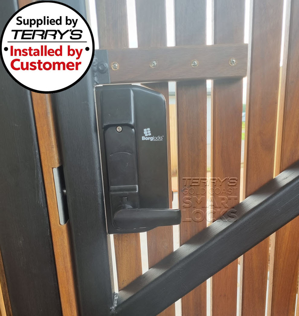 Borg forend fixing mechanical digital gate lock mounted on a metal-framed timber slat gate, viewed from the inside